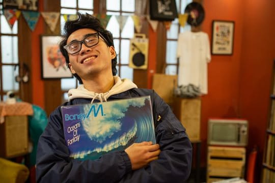Hung, Mitarbeiter des LP Club, hält die Schallplatte "Oceans of Fantasy" von Boney M.