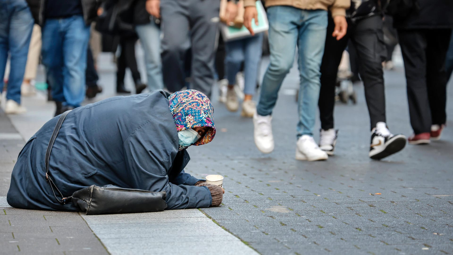 Eine Bettlerin mit Schutzmaske in der Düsseldorfer Altstadt: Politik für die Menschen oder die Konzerne?