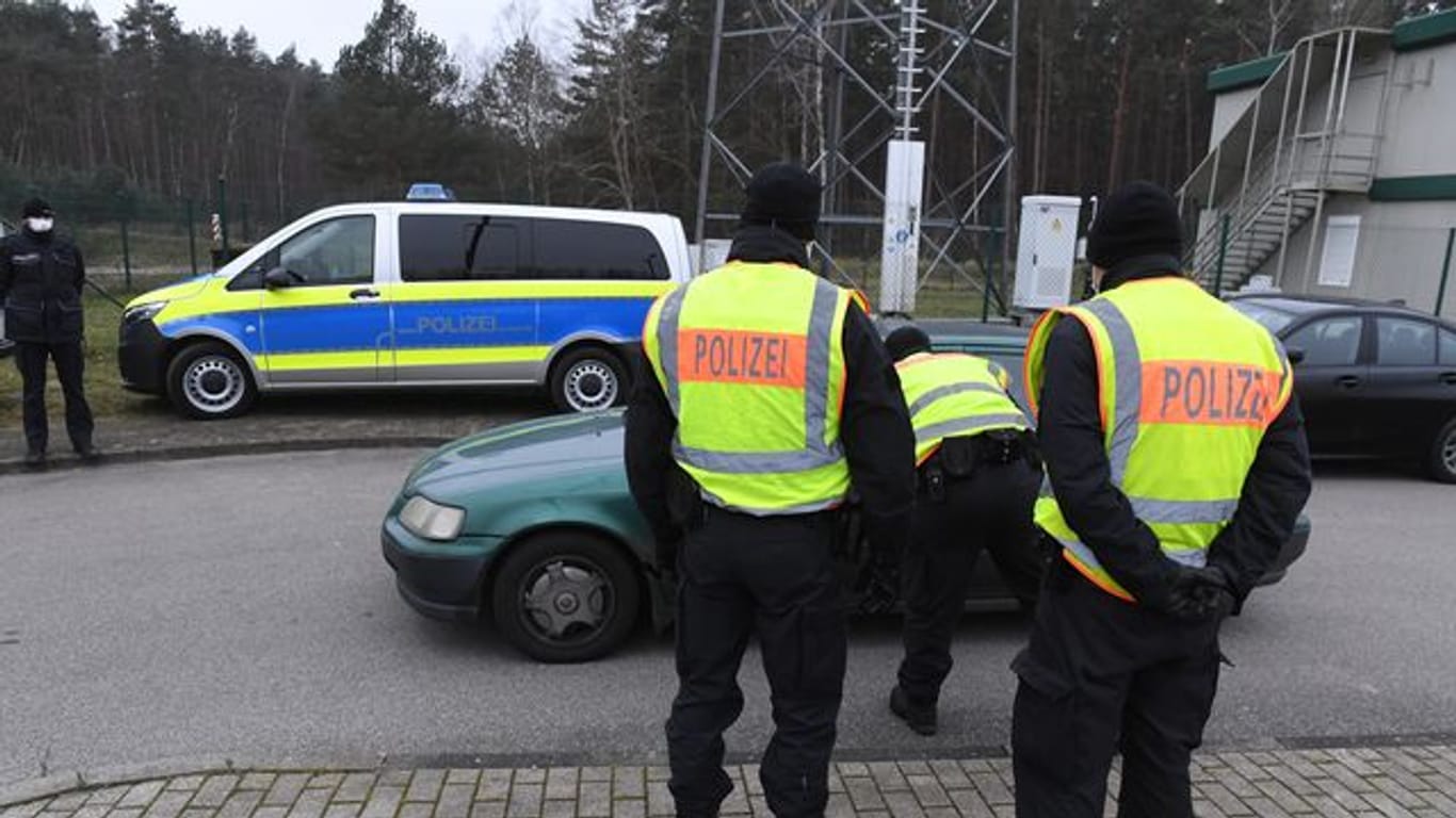 Polizisten kontrollieren ein Fahrzeug vor einem Grenzübergang nach Polen.