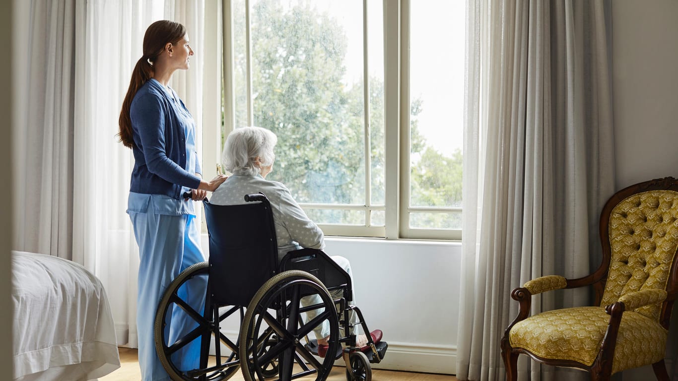 Pflegerin mit Seniorin im Altenheim: Pflegeheimbewohner gehören zur besonders gefährdeten Risikogruppe. (Symbolbild)