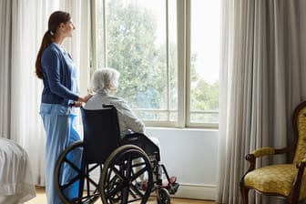 Pflegerin mit Seniorin im Altenheim: Pflegeheimbewohner gehören zur besonders gefährdeten Risikogruppe. (Symbolbild)