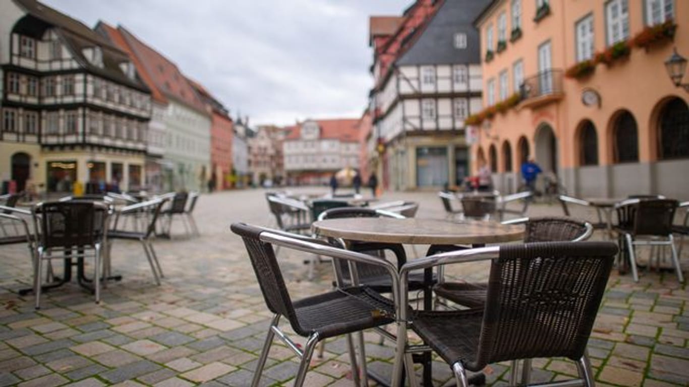 Unbesetzte Tische und Stühle eines geschlossenen Kaffees auf einem Marktplatz.