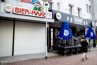 Hannover: Eine Passantin geht an einer geschlossenen Kneipe und einer Sushi-Bar im Stadtzentrum vorbei.