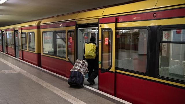 Ein Mann mit Mund- und Nasenschutz steigt in eine Bahn