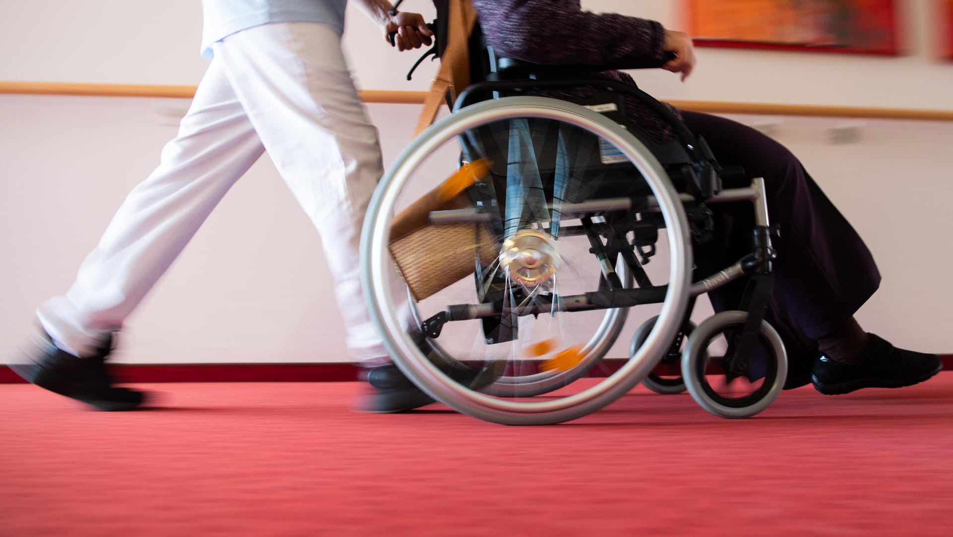 Medizinisches Personal schiebt einen Rollstuhlfahrer: Einige Menschen mit Behinderung werden in der Impf-Priorisierung nicht berücksichtigt (Symbolbild).