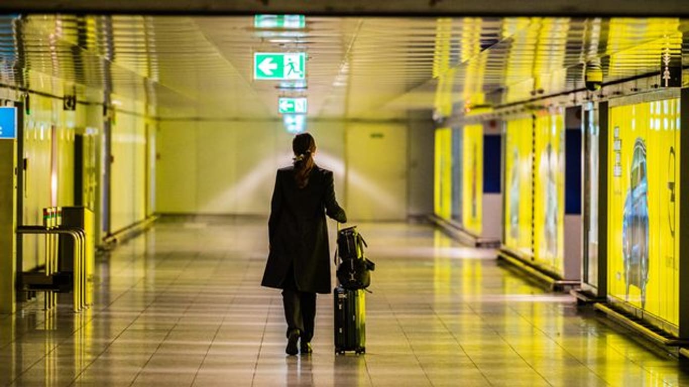 Frau mit Koffer im Flughafen Frankfurt (Archivbild): Die Bundespolizei verschärft die Corona-Kontrollen bei der Einreise aus Risikogebieten.