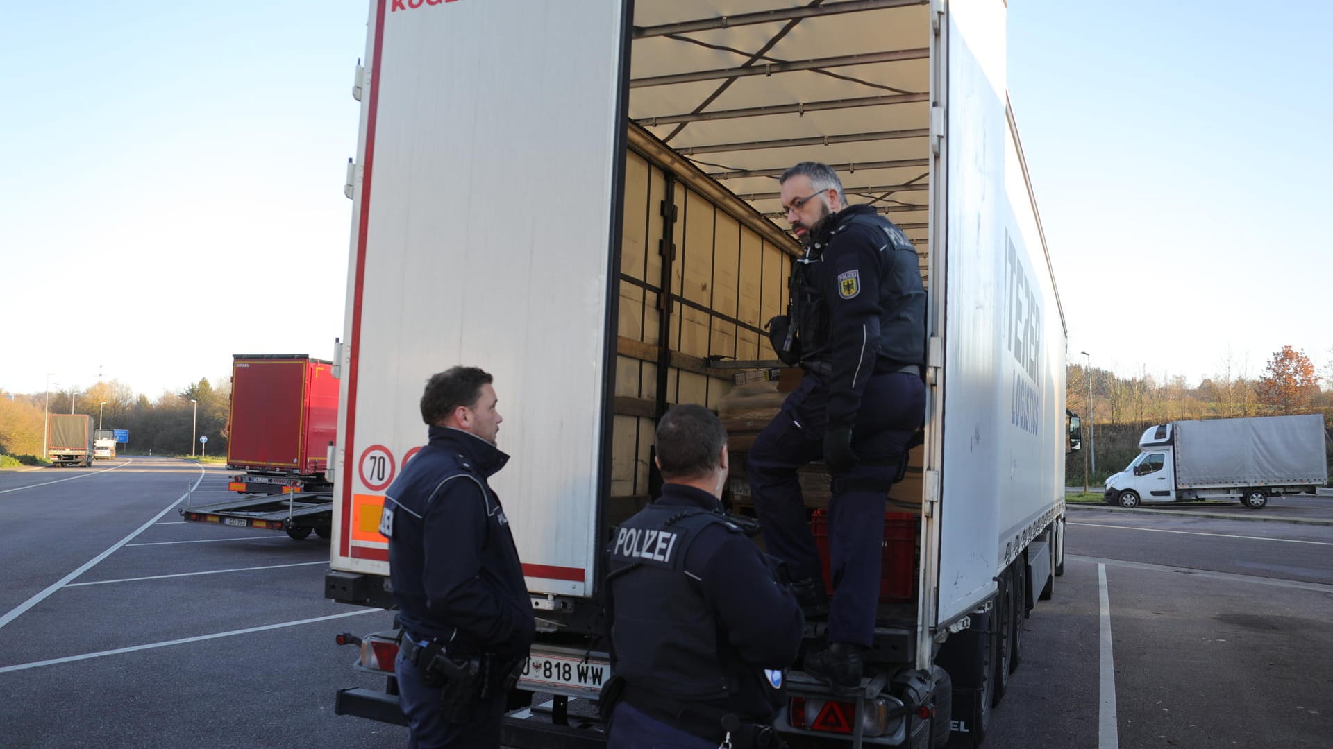 Polizisten untersuchen einen Lkw (Archivbild): Ein Lastwagenfahrer in Baden-Württemberg hat sechs geflüchtete Männer in seinem Laderaum entdeckt.