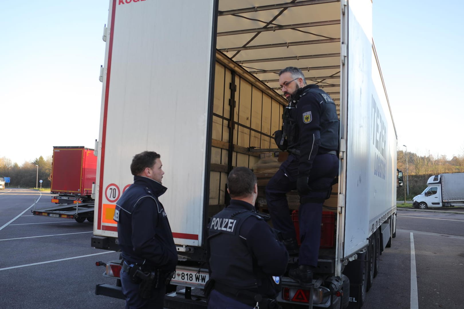 Polizisten untersuchen einen Lkw (Archivbild): Ein Lastwagenfahrer in Baden-Württemberg hat sechs geflüchtete Männer in seinem Laderaum entdeckt.