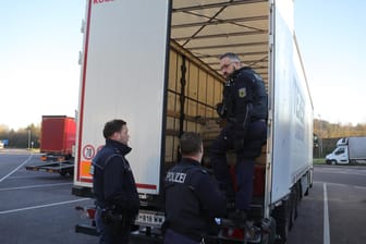 Polizisten untersuchen einen Lkw (Archivbild): Ein Lastwagenfahrer in Baden-Württemberg hat sechs geflüchtete Männer in seinem Laderaum entdeckt.