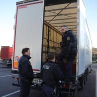 Polizisten untersuchen einen Lkw (Archivbild): Ein Lastwagenfahrer in Baden-Württemberg hat sechs geflüchtete Männer in seinem Laderaum entdeckt.