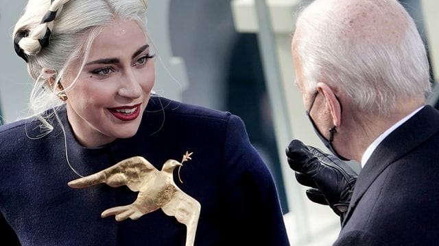 Lady Gaga mit goldener Friedenstaube bei der Amtseinführung von Joe Biden. Lady Gaga mit goldener Friedenstaube bei der Amtseinführung von Joe Biden.