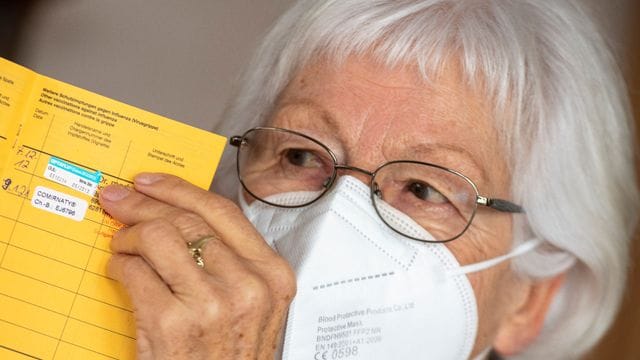 Seniorin Ursula Neuberger hält ihren Impfpass, in dem eine Grippe-Impfung (oben) und ihre erste Corona-Impfung vermerkt sind. Seniorin Ursula Neuberger hält ihren Impfpass, in dem eine Grippe-Impfung (oben) und ihre erste Corona-Impfung vermerkt sind.