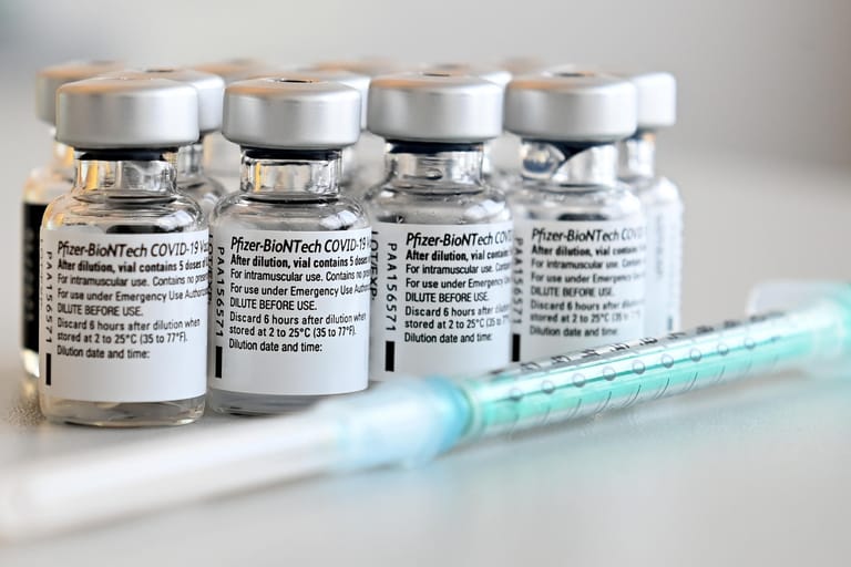 Spritze und Ampullen mit dem Covid-19-Impfstoff: Die Corona-Impfungen finden in regionalen Impfzentren statt. Die Terminvergabe erfolgt nach einem vom Gesundheitsministerium festgelegten Prioritätenprinzip.