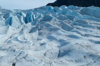 Zwei Menschen wandern auf einem Gletscher in Alaska.