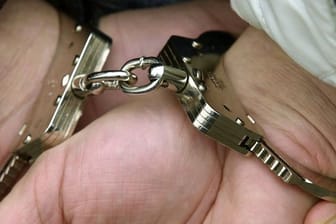 Hände in Handschellen (Symbolbild): In Spanien ist ein Verdächtiger festgenommen worden. Er soll 2019 einen 24-Jährigen in Leipzig erschossen haben.