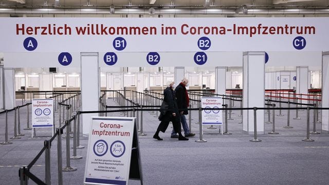 Zwei Senioren gehen durch das Impfzentrum in den Hamburger Messehallen zu ihrer Corona-Impfung (Symbolbild): Termine für die Impfung werden über ein zentrales System vergeben.