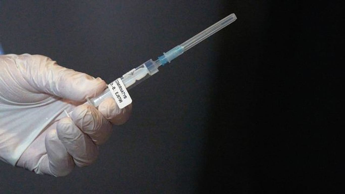 Eine medizinische Mitarbeiterin hält eine Spritze mit einem Impfstoff gegen Covid-19.