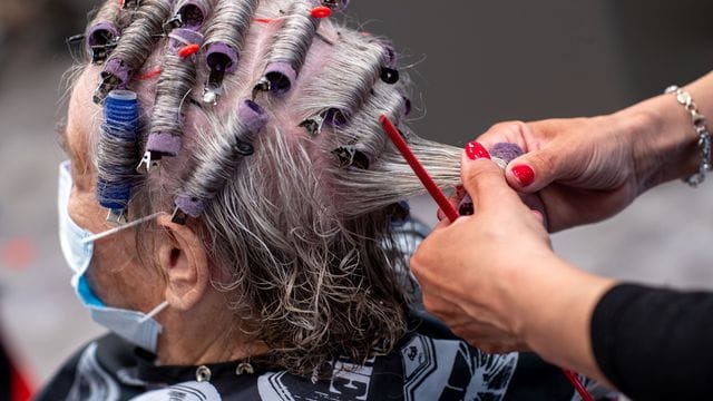 Einer Kundin werden in einem Friseursalon die Haare frisiert Einer Kundin werden in einem Friseursalon die Haare frisiert