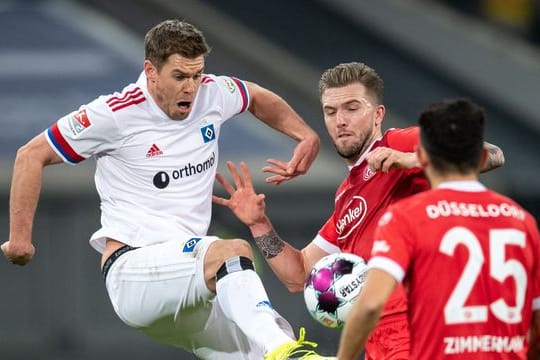 Düsseldorfs André Hoffmann (M) und HSV-Torjäger Simon Terodde teilten sich im Spitzenspiel die Punkte.