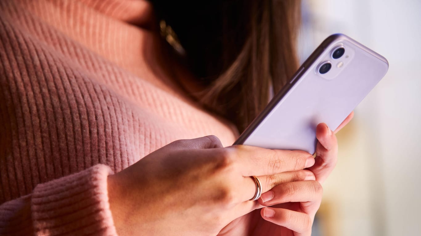 Eine Frau hält ein Smartphone (Symbolbild): Viele Freundschaften haben durch das Stalking gelitten.