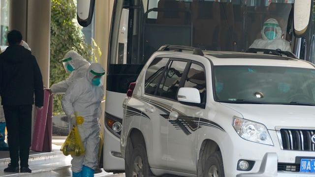 Ein Arbeiter in Schutzkleidung verlässt ein Quarantäne-Hotel in Wuhan. Ein Arbeiter in Schutzkleidung verlässt ein Quarantäne-Hotel in Wuhan.