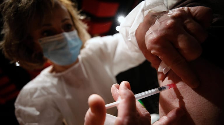 Ein Mann bekommt in einem Impfzentrum den Corona-Impfstoff von Moderna injiziert.