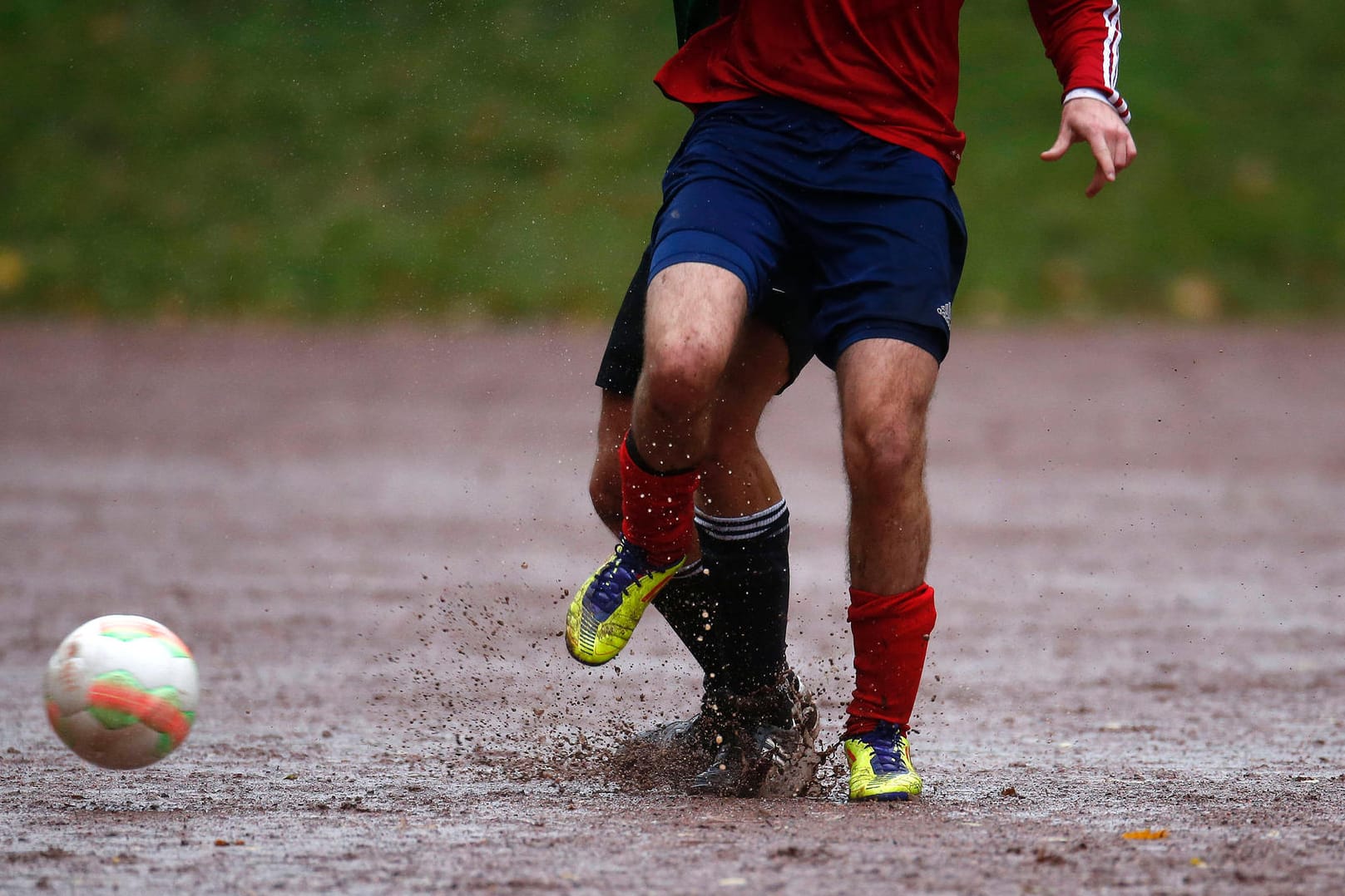 Fußballer auf dem durch Regen aufgeweichten Aschenplatz (Symbolbild): Im Oktober 2020 fanden die letzten Spiele statt.