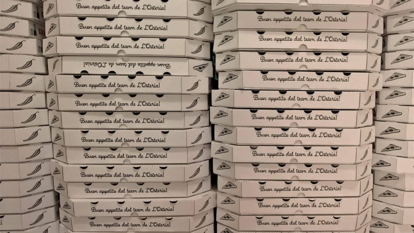 Gestapelte Pizzakartons von L'Osteria: Das Restaurant bietet nun FFP2-Masken an.