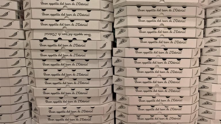 Gestapelte Pizzakartons von L'Osteria: Das Restaurant bietet nun FFP2-Masken an.