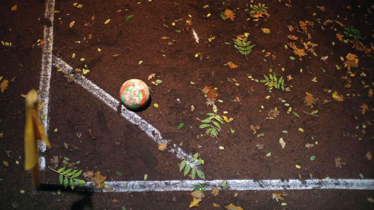 Ein Ball liegt zur Ausführung eines Eckballs auf dem mit Blättern bedeckten Aschenplatz bereit (Symbolbild): In Hamburg wird über den Abbruch der Saison diskutiert.