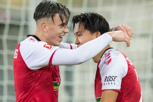 Woo-yeong Jeong (r) und Ermedin Demirovic feiern ein Tor für den SC Freiburg.