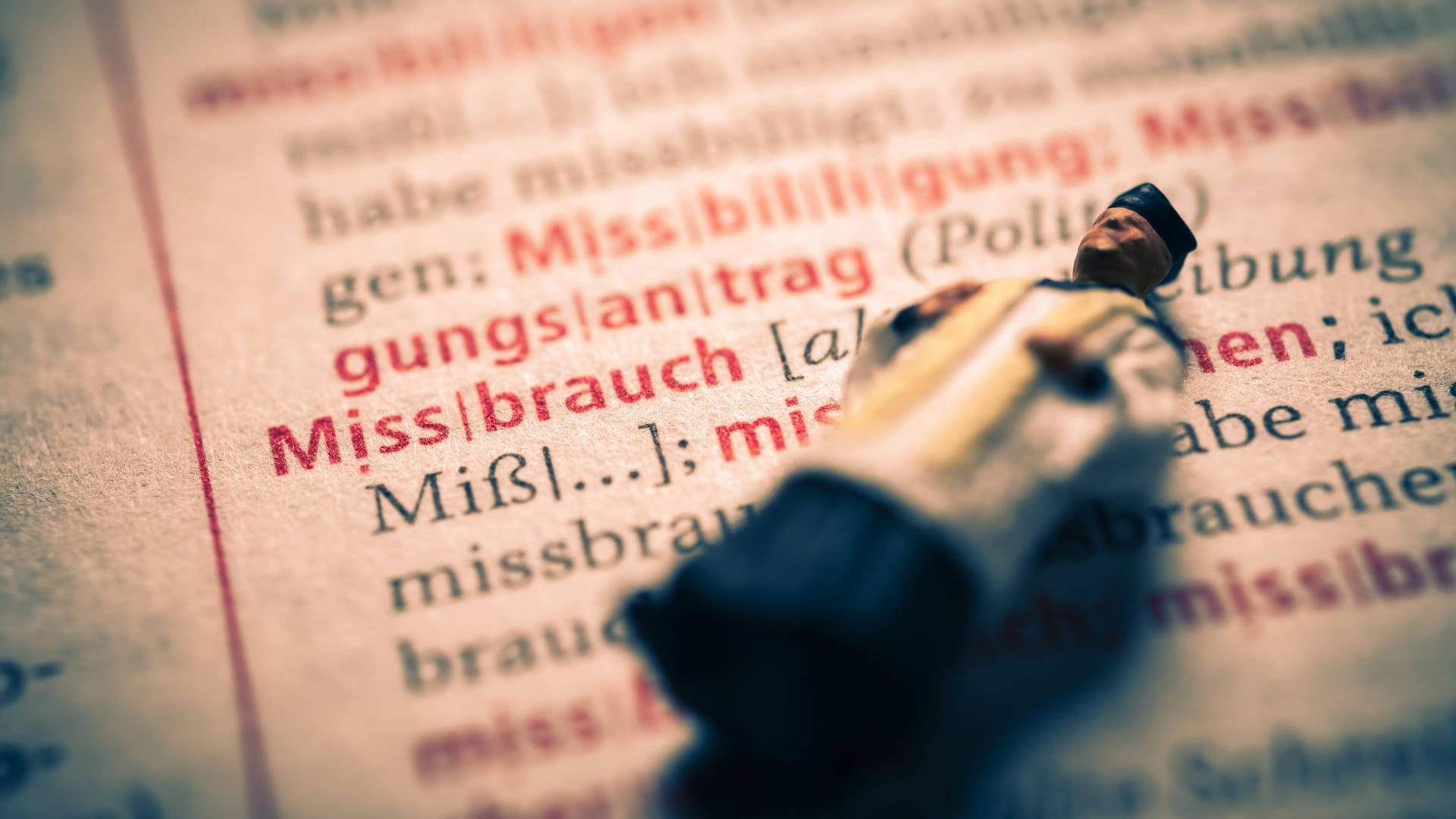 Miniaturfigur eines Priesters in einem Wörterbuch mit dem Wort Missbrauch: In Berlin ist ein Gutachten zum Missbrauch in der Kirche vorgestellt worden. Miniaturfigur eines Priesters in einem Wörterbuch mit dem Wort Missbrauch: In Berlin ist ein Gutachten zum Missbrauch in der Kirche vorgestellt worden.