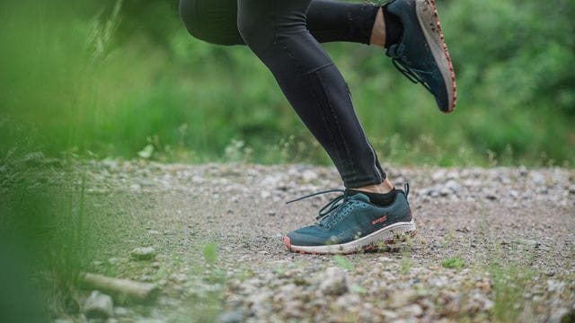 Eine Joggerin läuft über einen Waldweg