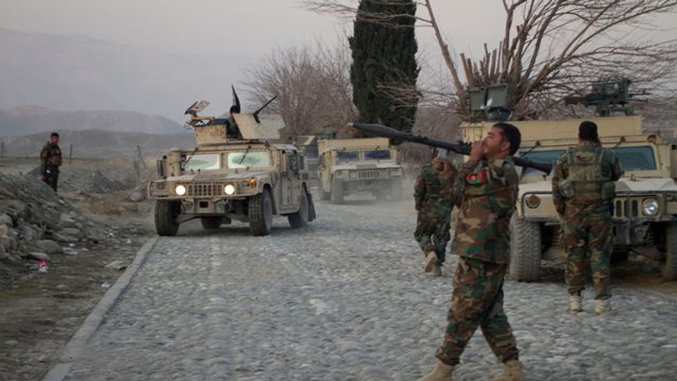 Mitglieder der afghanischen Sicherheitskräfte stehen am Ort eines Anschlages mit einer Autobombe nahe Nangarhar.