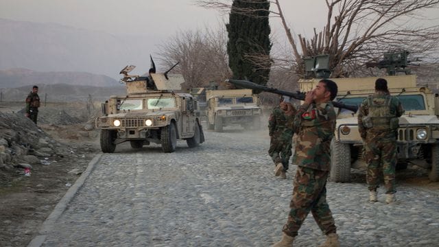 Mitglieder der afghanischen Sicherheitskräfte stehen am Ort eines Anschlages mit einer Autobombe nahe Nangarhar.