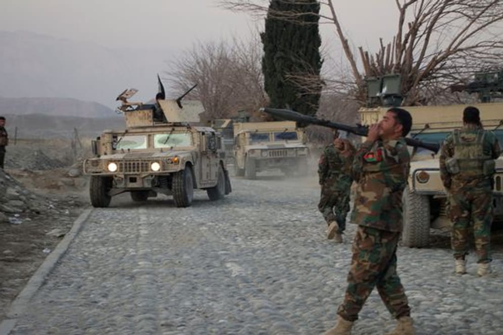 Mitglieder der afghanischen Sicherheitskräfte stehen am Ort eines Anschlages mit einer Autobombe nahe Nangarhar.