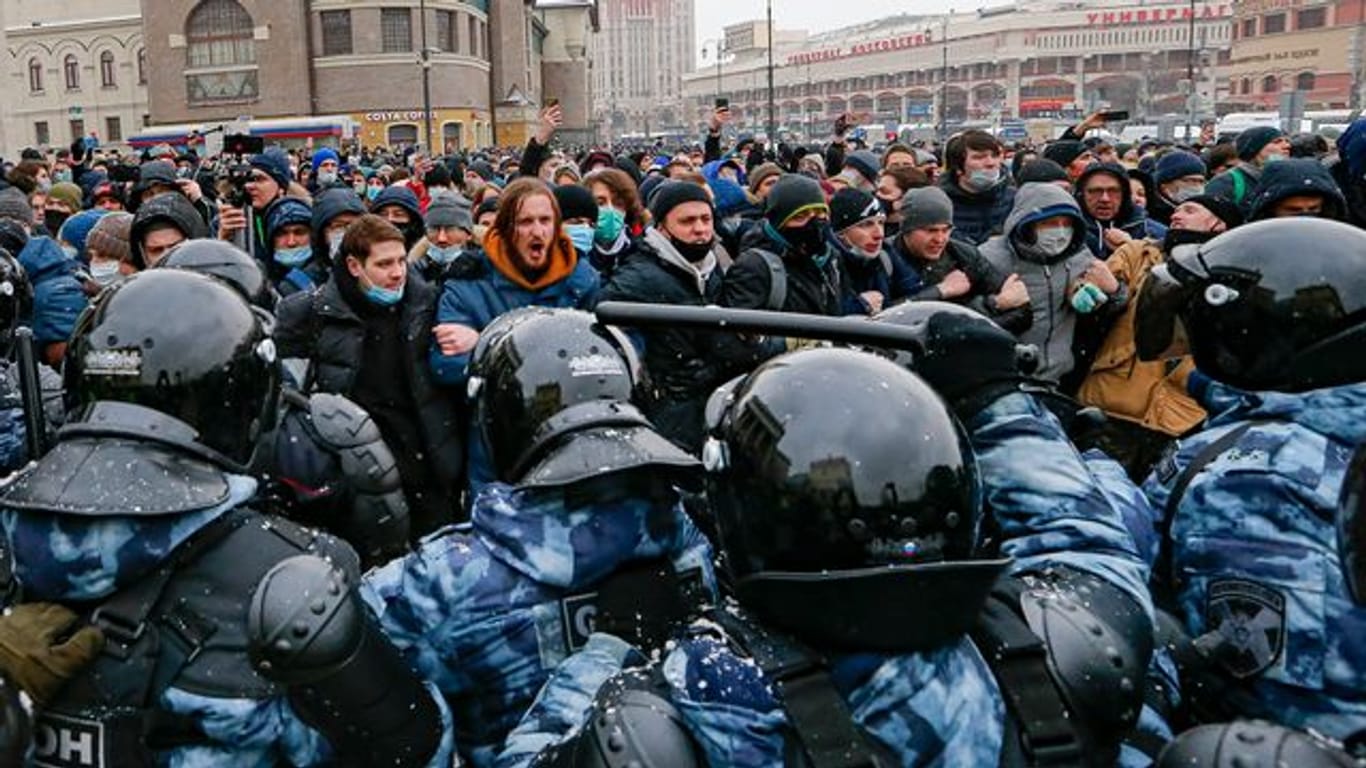 Aufeinandertreffen von Polizisten in Schutzkleidung und Demonstranten bei einem Protest in Moskau.