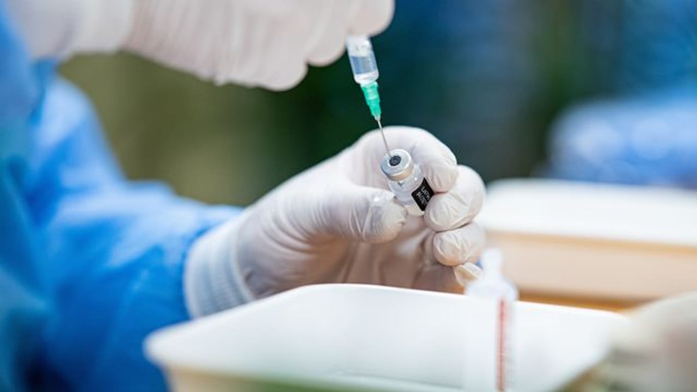 Ein Infektiologe zieht in einem Seniorenheim eine Spritze mit Impfstoff gegen das Coronavirus auf.