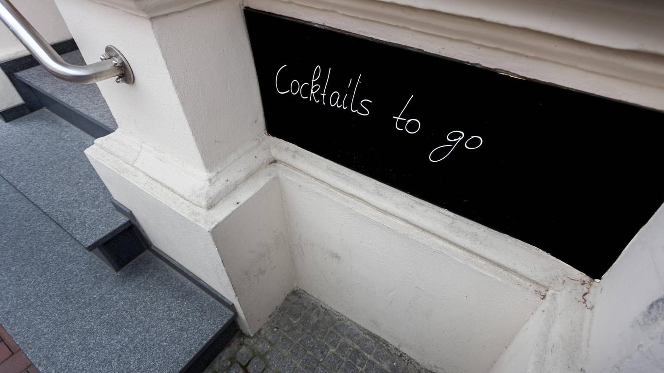 An einer Bar ist ein Schild "cocktails to go" angebracht (Symbolbild): In Köln dürfen Bars wieder Alkohol verkaufen.