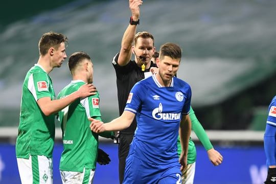 Schiedsrichter Sören Starke zeigt dem Schalker Klaas-Jan Huntelaar nach einem Foul die Gelbe Karte.