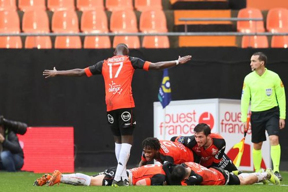 Lorients Laurent Abergel, auf dem Spielfeld liegend, jubelt mit den Teamkameraden über seinen Treffer zum 1:0.