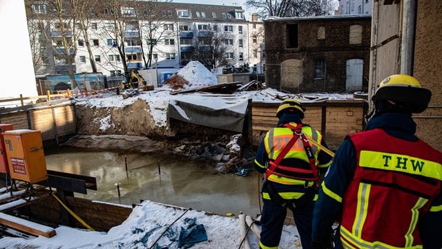 Einsatzkräfte des Technischen Hilfswerks (THW) stehen an der mit Wasser gefüllten Baugrube in Berlin-Köpenick. Einsatzkräfte des Technischen Hilfswerks (THW) stehen an der mit Wasser gefüllten Baugrube in Berlin-Köpenick.