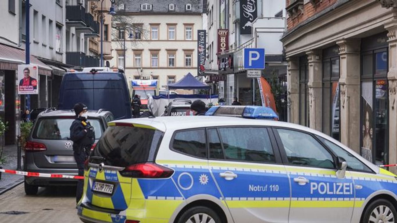 Von Polizeifahrzeugen und der Spurensicherung abgeschirmt ist der Tatort in der Innenstadt von Wiesbaden.