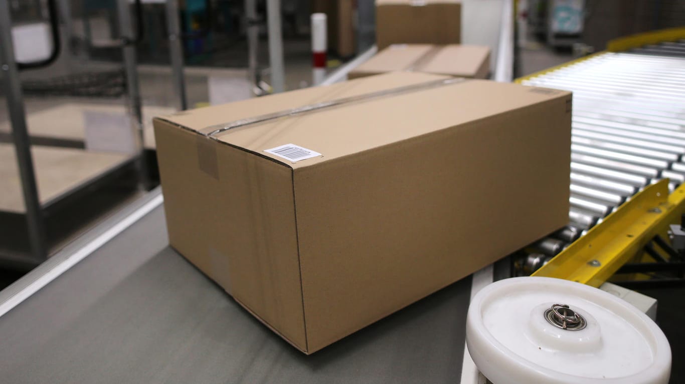 Verpackte Kartons auf einem Transportband (Symbolbild): Im Vereinigten Königreich wird Pappe knapp.