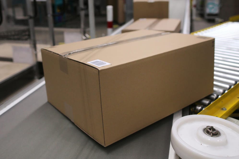 Verpackte Kartons auf einem Transportband (Symbolbild): Im Vereinigten Königreich wird Pappe knapp.