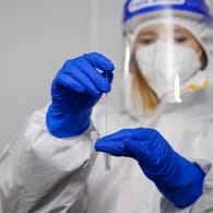 Eine Frau hantiert mit einem Corona-Test (Symbolbild): In Köln kann man sich an vielen Orten auf das Coronavirus testen lassen.