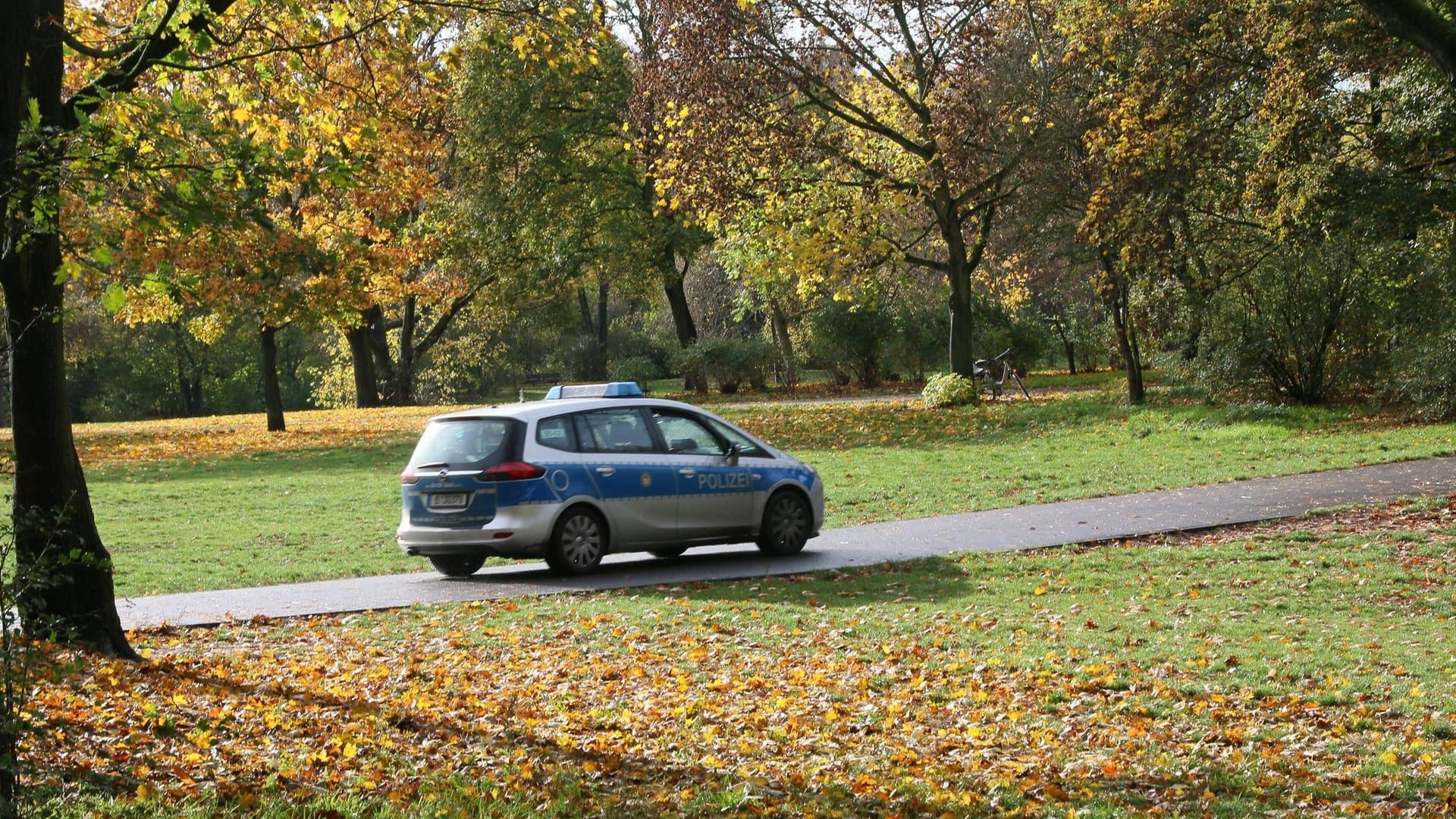 Ein Polizeiauto fährt durch einen Park: In der Hasenheide hatte es einen schweren Angriff gegeben – das Opfer ist nun gestorben.