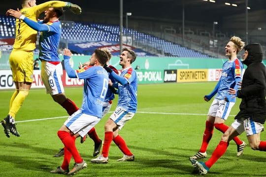 Kiels Torwart Ioannis Gelios (l) und seine Mitspieler feiern ihren Sieg mit 7:6 nach Elfmeterschießen.