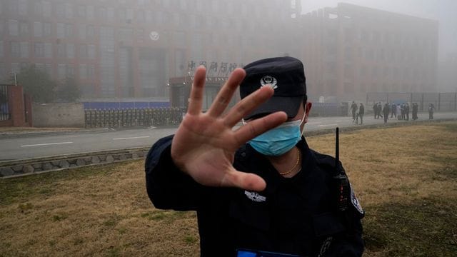 Ein Sicherheitsmann stoppt Journalisten vor dem Institut für Virologie in Wuhan. Ein Sicherheitsmann stoppt Journalisten vor dem Institut für Virologie in Wuhan.