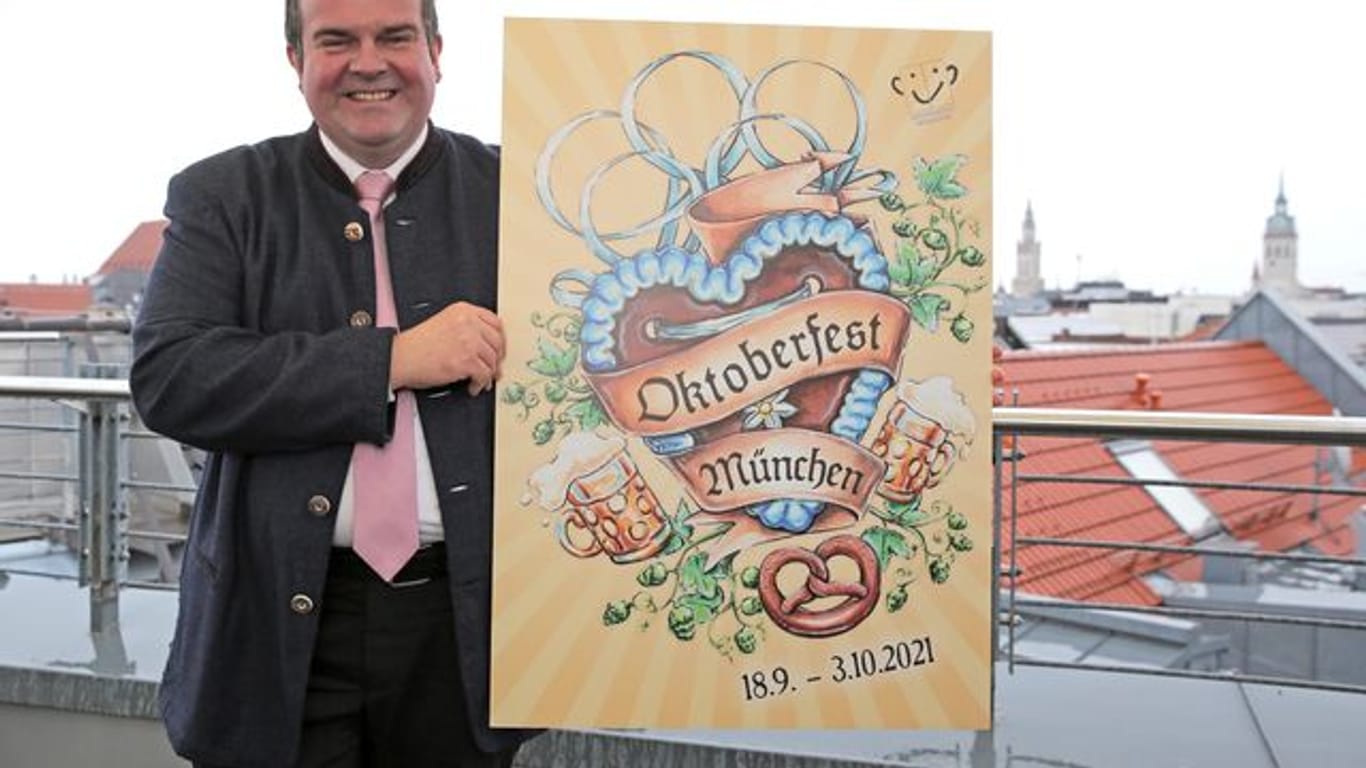 Clemens Baumgärtner (CSU) hält das Siegermotiv für das Oktoberfest-Plakat 2021 in den Händen: Ob die Wiesn dieses Jahr stattfinden kann, ist noch unklar.